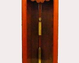 New Haven #10 Jewelers Regulator - A late 19th century New Haven No. 10 model standing regulator.  8-day time only weight driven movement with dead beat escapement, maintaining power Brass cylinder pendulum and porcelain dial with Roman numerals and sweep seconds.  Black Walnut case with carved pediment crown over a single long door with arched glass, applied bosses and a paneled base with simple molded plinth.  Older refinishing with minor wear, several dial feet detached, running when cataloged.  26 3/4 x 13 x 90 1/2" high.  ESTIMATE $1,500-2,500
