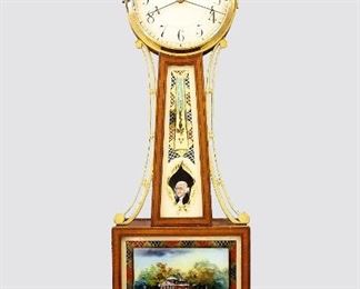 Waltham Presentation Banjo Clock - A 1930's Waltham Presentation Banjo clock.  8-day weight driven time only movement with maintaining power and Geneva stop marked "Waltham Clock Co. USA, 8739", painted metal dial marked "Waltham" with Arabic numerals.  Mahogany case with applied Brass "rope" detail having a gilded Eagle finial above circular Brass upper door with convex glass over a throat glass with reverse painted decoration and Jefferson portrait, Brass side arms over a  lower door with reverse painted decoration of Monticello over a carved drop with Mahogany spheres and fluted detail.  Original finish with minor wear, some flaking and touchups on glasses, running when cataloged.  41" high.  ESTIMATE $600-800
