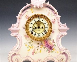 Ansonia La Bretagne China Shelf Clock - A turn of the century Ansonia "La Bretagne" model china shelf clock.  8-day time and strike movement with visible escapement, two part porcelain dial and Roman numerals.  Porcelain case with floral decoration and gilded detail.  Some wear and crazing, running when cataloged.  14 3/4" high.  ESTIMATE $200-300
