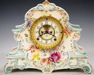 Ansonia La Nord China Shelf Clock - A turn of the century Ansonia "La Nord" model china shelf clock.  8-day time and strike movement with visible escapement, two part porcelain dial and Arabic numerals.  Royal Bonn porcelain case with floral decoration and gilded detail.  Some wear and crazing, hairlines in dial, running when cataloged.  11 3/4" high.  ESTIMATE $200-300
