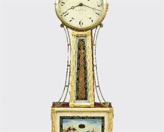 A Willard Jr. Presentation Banjo Clock - A 19th century American Presentation Banjo clock.  8-day weight driven time only movement with a painted iron dial and Roman numerals signed "A. Willard Jr, Boston".  Mahogany case with gilded front, Brass finial over a molded Brass dial door, tapered throat panel with applied rope moldings and reverse painted glass flanked by shaped Brass side arms, lower door with a reverse painted Naval Battle scene labeled "United States-Macedonia" above a shaped drop with carved detail.  Some dial wear, minor loss to gilding, touchups to the glasses, replaced finial, running momentarily when cataloged.  40 1/2" high overall.  ESTIMATE $3,000-4,000

