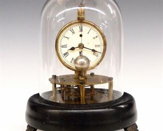 E N Welch Briggs Rotary Clock - A late 19th century E. N. Welch "Briggs Rotary" model novelty clock.  30-hr time only movement with a papered metal dial and Roman numerals.  Turned wooden base with Black paint and cast paw feet with a glass dome cover.  Minor wear, dial discoloration, running when cataloged.  7 1/4" high overall. 