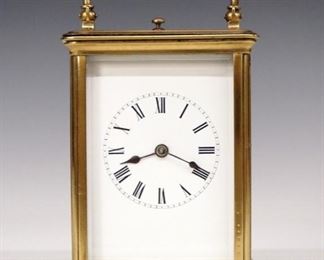 French Carriage Clock - An early 20th century French carriage clock.  8-day time and strike movement with repeat button, platform escapement and porcelain dial with Roman numerals.  Brass case with fold down handle and beveled glasses.  Minor wear, running when cataloged.  5 3/4" high.  ESTIMATE $300-400
