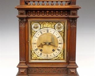W & H Bracket Clock - A turn of the century Winterhalder & Hofmeier bracket clock.  8-day dual wind movement with quarter hour strike on two coiled gongs, Brass dial with cast spandrels, Silvered chapter ring with Roman numerals and subsidiary Chime/Silent and Slow/Fast dials.  Walnut case with turned gallery top over a Brass dial door with beveled glass flanked by fluted columns with carved capitols above a cared frieze and molded base.  Original finish with minor wear, running when cataloged.  17" high.  ESTIMATE $400-600

