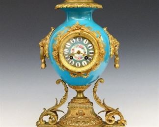 French Bronze And Porcelain Mantle Clock -
A 19th century French Bronze & Porcelain mantle clock by Vincenti et Cie, Paris, retailed Camerden & Forster, New York.  8-day time and strike movement with a painted porcelain dial and raised Roman numerals marked "Carmerden & Forster".  Medium Blue porcelain body with gilded Bronze base and mounts including Lion's mask handles and "Love Birds" finial.  Minor surface wear, running when cataloged.  18 3/4" high.  ESTIMATE $800-1,200
