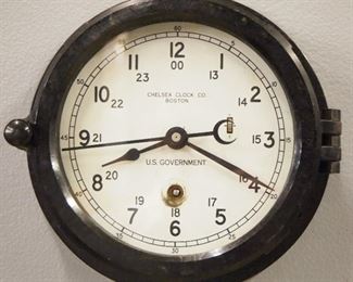 Chelsea Ships Clock - A mid 20th century Chelsea engine room clock.  8-day time only movement with painted dial marked "Chelsea Clock Co, Boston, U. S. Government", 24-hr Arabic numerals and sweep seconds.  Black phenolic case with hinged front door.  Some wear, dial wear at winding arbor, running when cataloged.  7 1/2" diameter overall.  ESTIMATE $200-300

