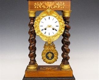 French Portico Clock - A 19th century French Portico clock by S. Marti, Paris.  8-day time and strike movement with a porcelain dial, Gilded Bronze surround and pendulum, Roman numerals and Gilded filigree hands.  Rosewood case with inlaid flower basket decoration, "rope" turned columns with Gilded Bronze capitols and bases.  Old finish with minor wear, hairline in dial, running when cataloged.  19" high. 