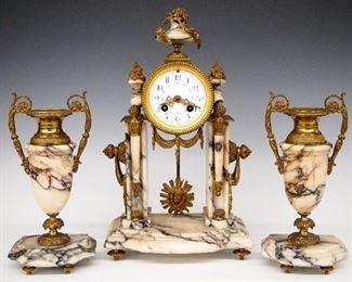 A D Mougin French Bronze And Marble Clock Set - A turn of the century French three piece clock set by A. D. Mougin, Paris.  8-day time and strike movement with convex porcelain dial, Arabic numerals and painted garland detail with a Bronze sunburst mask pendulum.  Peach/Gray marble case with urn finial and gilded Bronze mounts accompanied by two matching Bronze and marble garniture vases.  Some wear to case, lacks rear door, running when cataloged.  Clock is 14 1/2" high and the garnitures 10" high. 
