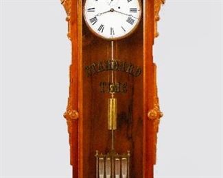 Reproduction Howard No. 60 Wall Regulator - Reproduction of a Howard "No. 60" model wall regulator.  8-day time only weight driven movement with four jar Mercury pendulum and painted metal dial with Arabic numerals and subsidiary seconds.  Mahogany case with scrolled top and turned finial over a single arched door with carved ears and gilded "Standard Time" glass and shaped lower drop with three turned finials.  Original finish with slight wear, running when cataloged.  79" high overall.