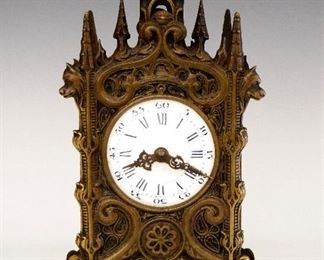 A turn of the century French Gothic Revival Bronze desk clock.  8-day time and strike triple train movement with Angelus Prayer Striking at 6:00 a.m., Noon and 6:00 p.m. (3 single tone sets of three strikes followed by 20 two tone strikes), a convex porcelain dial with Roman numerals and filigree hands.  Cast Bronze case features Gothic arches and tracery with Wolves mask and paw feet detail.  Minor case wear, movement quite dirty, running momentarily when cataloged.  9 1/2" high.  ESTIMATE $400-600