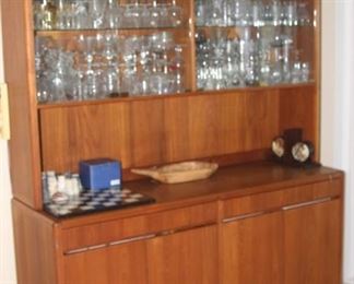 Teak bar cabinet, with upper glass doors, lower storage drawers and shelves.