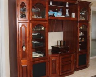 Three piece entertainment center with cd/dvd storage, lights and glass display shelves with doors.