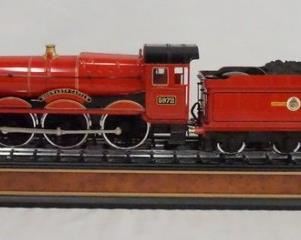 1104 HARRY POTTER HOGWARTS RAILWAYS DIE CAST STEAM LOCOMOTIVE & TENDER ON TRAIN TRACKS BASE. BASE IS 22 1/2 X 3 3/4 IN.