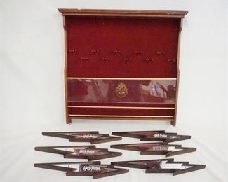 1130 GROUP OF HARRY POTTER WAND DISPLAYS, LOT INCLUDES A HANGING WALL DISPLAY 19 3/4 IN X 18 3/4 IN, 2 IN DEEP & 6 STANDS FOR WANDS. ALL PIECES HAVE SOME DAMAGE.