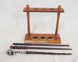 1182 LOT OF THREE HARRY POTTER WANDS & A WAND DISPLAY. DISPLAY IS 8 IN X 9 IN 3 1/4 IN DEEP.
