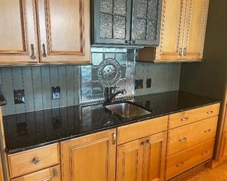 Cabinets, black marble counter, stainless sink