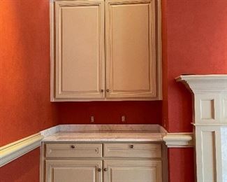 Upper and lower white cabinets with white marble counter, the lower cabinet has 2 felt-lined silverware drawers