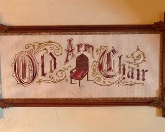 Punched paper embroidery of “Old Arm Chair” in red, framed in Victorian carved oak leaf corners criss-cross frame