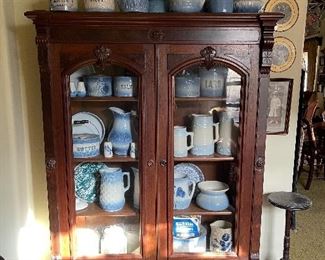 Large collection of blue salt glaze stone ware in an antique walnut cupboard