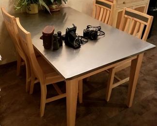 Steel top kitchen table, four chairs & matching cupboard. Silk plants, binoculars & old cameras  