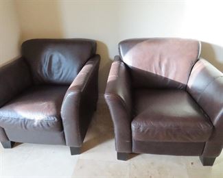 Pair of great leather chairs in brown - sunlight is hitting them.