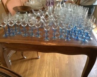 Several sets of blue stemmed glassware