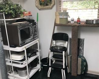 Rolling  cart , Cookmatic microwave, Presto pressure cooker, black and white metal kitchen fold out chair. 