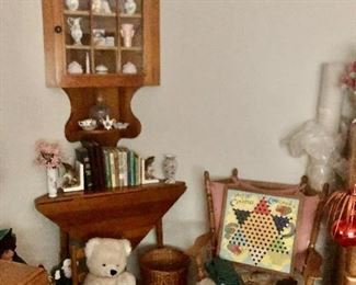 Wall cabinet, corner drop leaf table, small cane seat chair with stuff bear, books, straight back chair with vintage chinese checker board.
