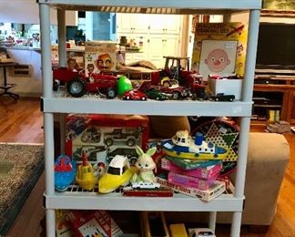 Top shelf: Colorforms Batman and Ninja Turtles, Lunapark, Matchbox Thunderbirds, 2nd shelf: ERTL International tractor and wagon, Massey Ferguson 3070 tractor,Dapper Dan magnetic man, McDonald’s McNuggets, Nylint horse trailer and truck. Third row : Gay Toys plastic boats, Buddy L Super Brutes police set, vintage puzzles. Fourth row: America Plastic Toys Co.  school buses,  Processed Plastic Co squad car, Mosaic Magic design and more!