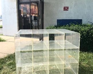 A 16-cubby acrylic shelving unit that measures 4 feet wide, 37” tall and 32” deep.