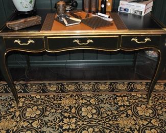 The Black Painted Wood Desk with Gold Paint and Brass Hardware, 55"w x 30.25"h x 29"D,  The Desk Top is Black Leather with Gold Paint Inlay