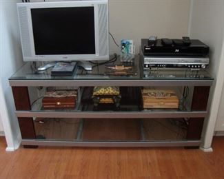AKAI COMBO TV WITH DVD PLAYER (FAR LEFT), BLU-RAY DVD PLAYER (RIGHT). MEDIA CENTER IS GLASS WITH FAUX TORTOISE ACCENTS.