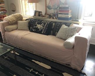 Very nice long sofa with pink slipcover 