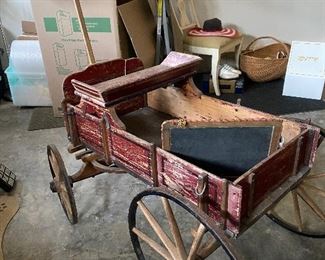 Primitive red wood pull cart.  Wheels are iron with wood spokes.