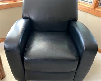 The third black leather chair, unfortunately has some damage in headrest area.