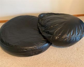 Large black "leather" floor pillow loungers.