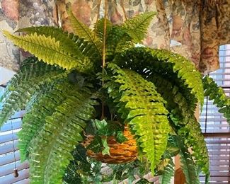 Faux fern plant in wicker hanging basket