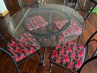 Beveled glass and iron table and 4 chairs upholstered in Black Hawks
