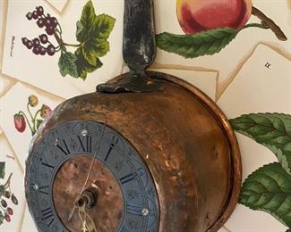 Antique copper pot that has been covered into a wall clock.