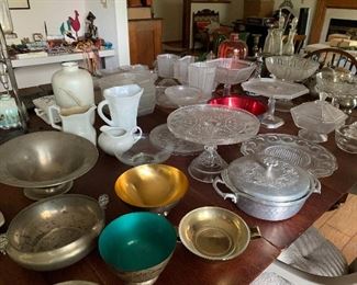 Assorted glass, pewter, and silver platters, bowls, serving dishes