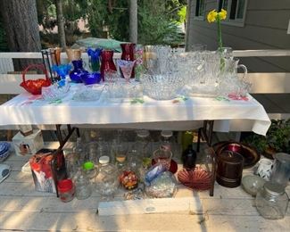 three tables of glass misc. kitchen, newer pots, pans, and more.