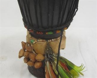 SMALL CONGA DRUM DECORATED WITH FEATHERS AND DRIED SEEDS. 10 1/8" TALL