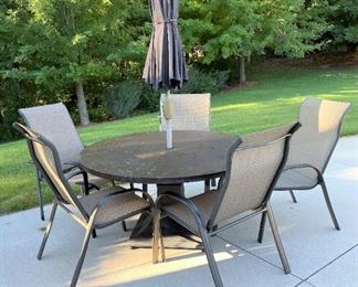 Round outdoor table with chairs and umbrella