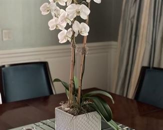 Faux orchid in white cachepot. 