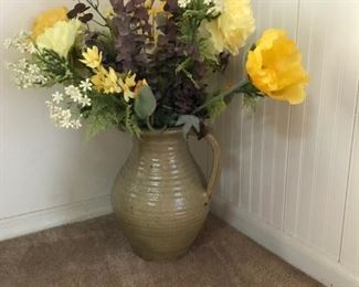 Floral arrangement in stoneware pitcher.