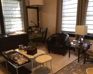 Black leather barrel chair, glass desk and ottoman. Very cool vintage microphone. Hanging light. 