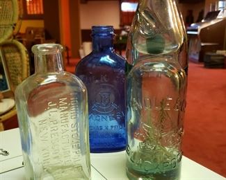 Three antique glass bottles including Hindle & Co. BlackPool, Milk of Magnesia and Liquid Stove Polish
