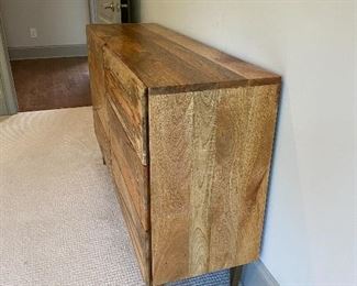 Roar & Rabbit™ Geo Inlay 6-Drawer Dresser   for West Elm   Overall: 54"w x 16"d x 34"h.  
Mango: Solid raw mango wood. Shiny Brass-finished metal details and legs.
Bone: Kiln-dried solid wood frame in a Bone finish. Metal legs and details in a Silver finish.  Made in a Fair Trade Certified™ facility, directly benefiting the workers who make it.
The mango wood used on this product is sustainably sourced from trees that no longer produce fruit.
Wood finish is natural and may vary slightly.
Drawers open from the side on angled metal glides.
Anti-tip kit hardware (included) is highly recommended to provide protection against tipping of furniture.