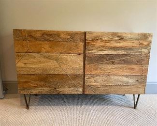 Roar & Rabbit™ Geo Inlay 6-Drawer Dresser   for West Elm   Overall: 54"w x 16"d x 34"h.  
Mango: Solid raw mango wood. Shiny Brass-finished metal details and legs.
Bone: Kiln-dried solid wood frame in a Bone finish. Metal legs and details in a Silver finish.  Made in a Fair Trade Certified™ facility, directly benefiting the workers who make it.
The mango wood used on this product is sustainably sourced from trees that no longer produce fruit.
Wood finish is natural and may vary slightly.
Drawers open from the side on angled metal glides.
Anti-tip kit hardware (included) is highly recommended to provide protection against tipping of furniture.