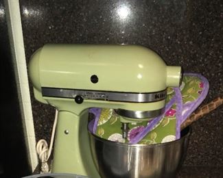 sage green KitchenAid mixer w/ several attachments